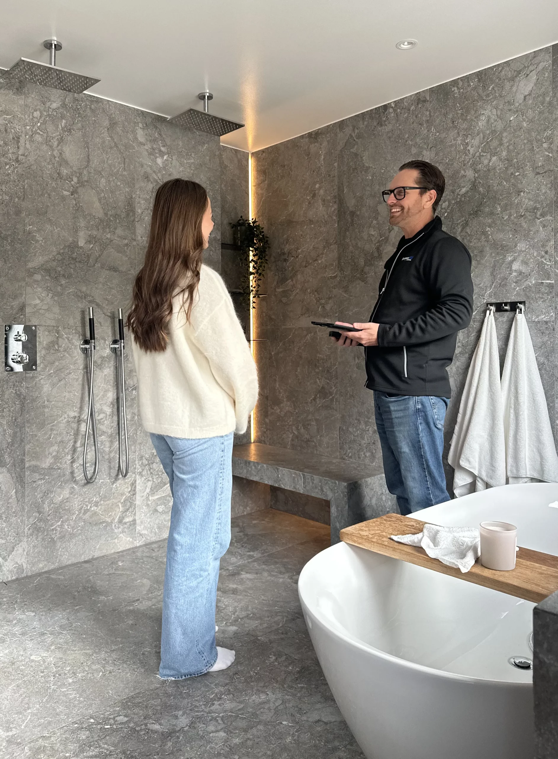 Bild på en kund och en person från RenoveraNu som står i ett badrum och pratat