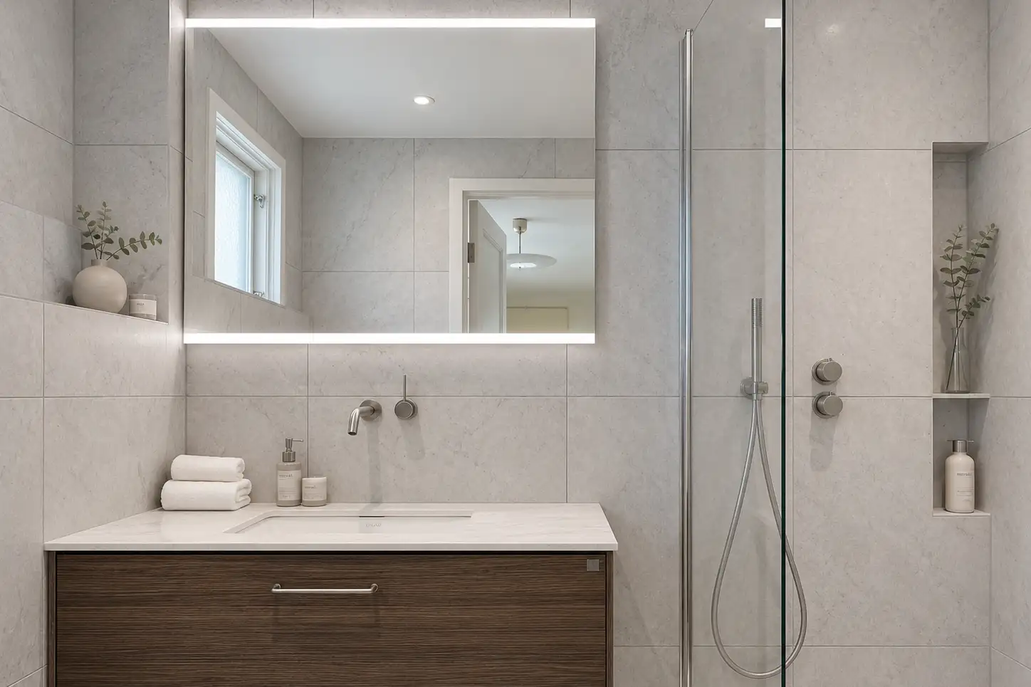 Elegant takdusch i krom med stora kakelplattor i naturstenslook. Badrumsrenovering gjort av renovera Nu.